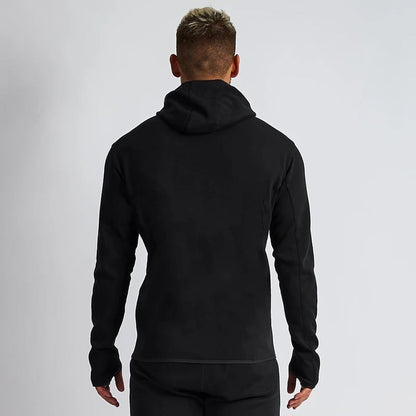 Person wearing a black hoodie from behind on a light gray background