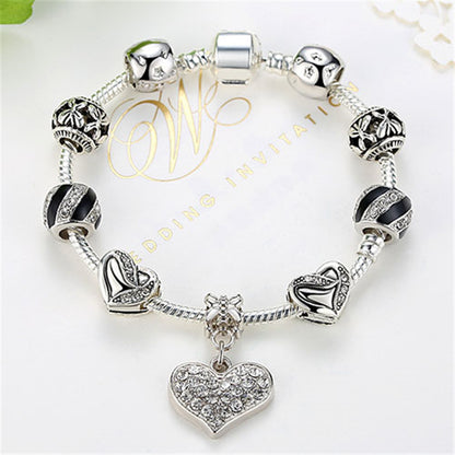 Silver bracelet with heart charm on a white background