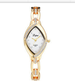 Gold and white watch with diamond-like accents on a white background