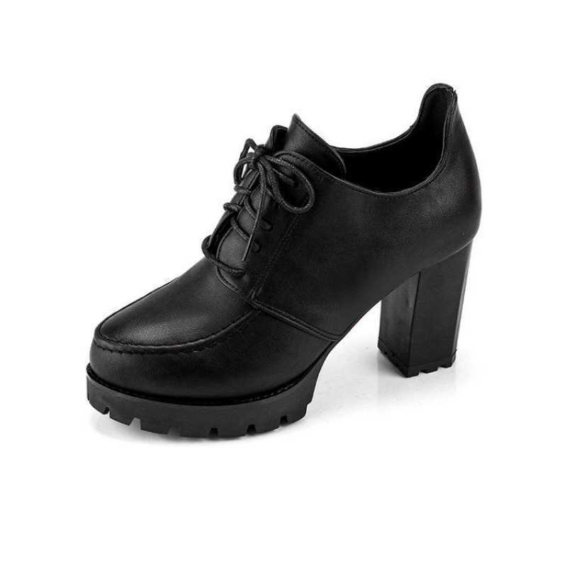 Black platform shoe with a block heel on a white background