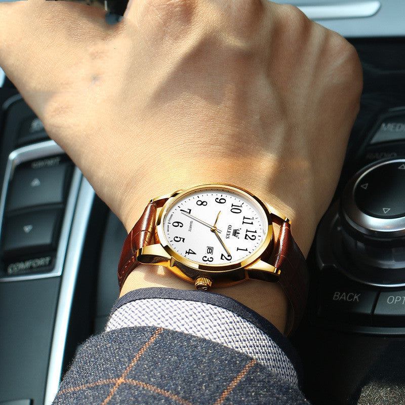 Gold wristwatch on a person's wrist with car interior background