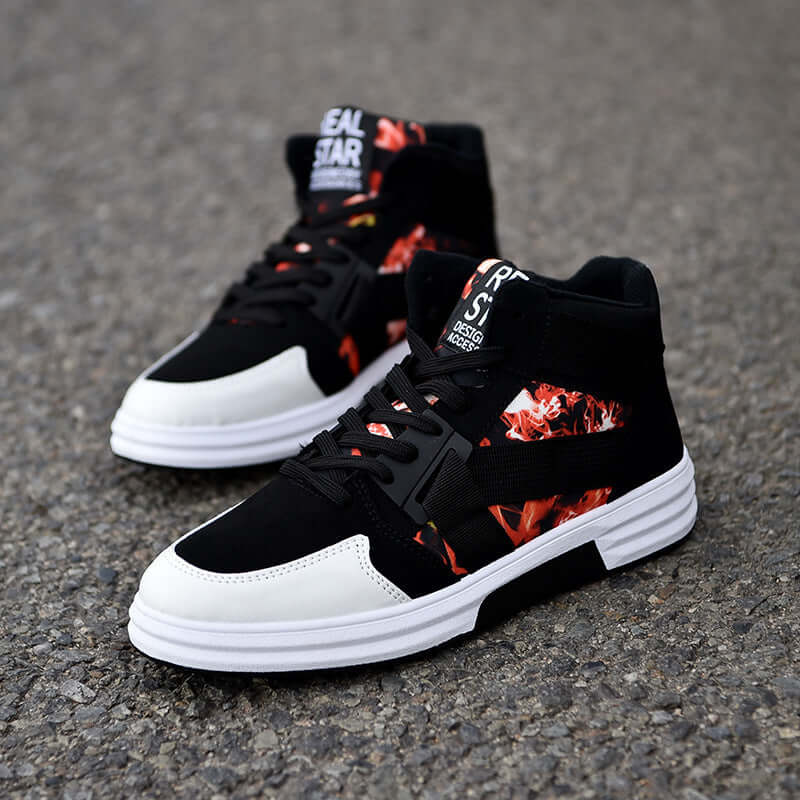 Black and white sneakers with red floral patterns on a gray pavement background