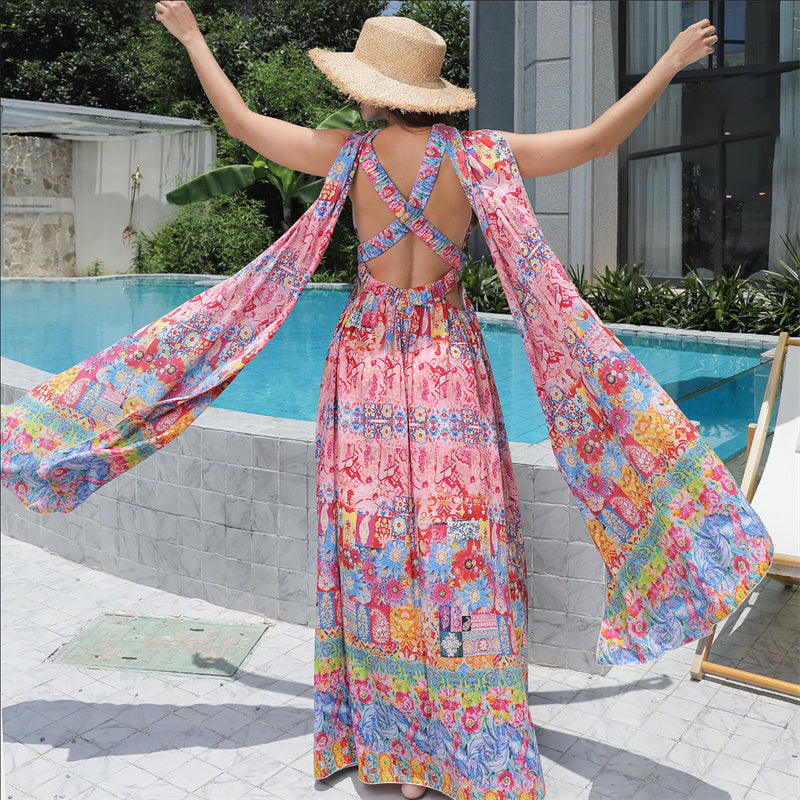 Person wearing a colorful floral dress by a poolside
