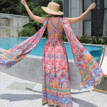 Person wearing a colorful floral dress by a poolside