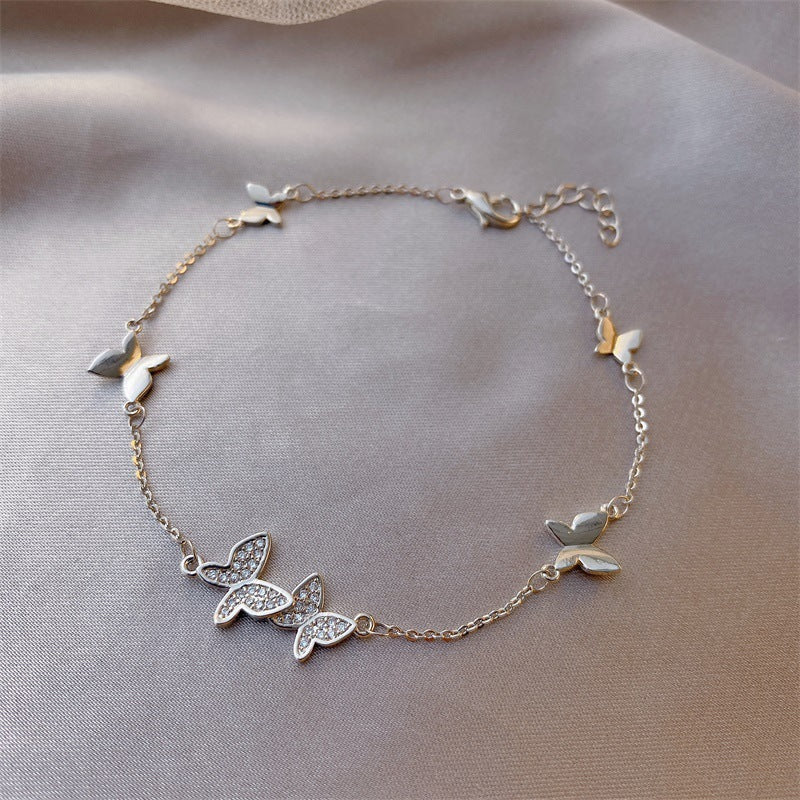 Delicate butterfly-themed bracelet on a soft fabric background