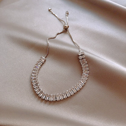 Silver beaded bracelet on a beige fabric background