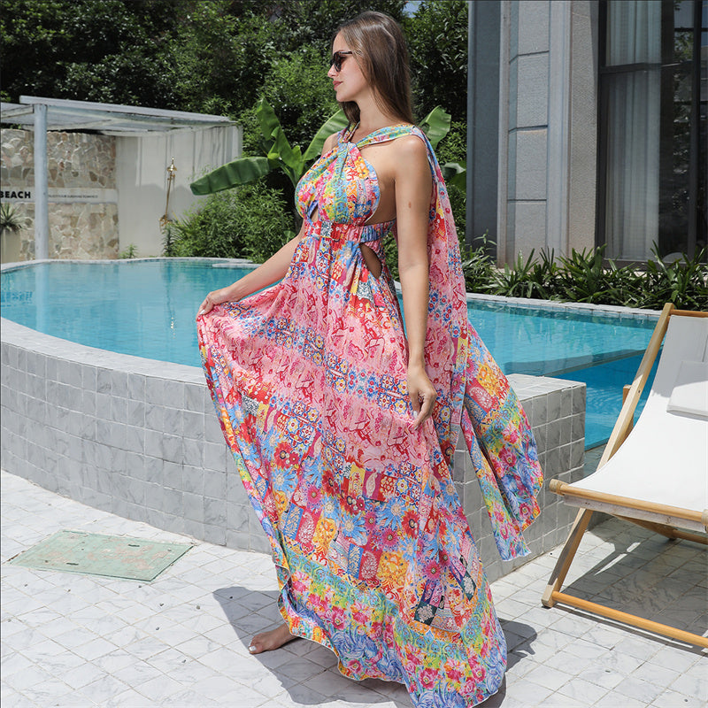 Woman in a colorful floral dress standing by a poolside.