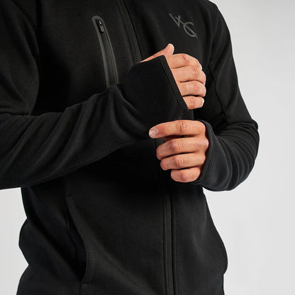 Person wearing a black jacket with a brand logo on a light gray background